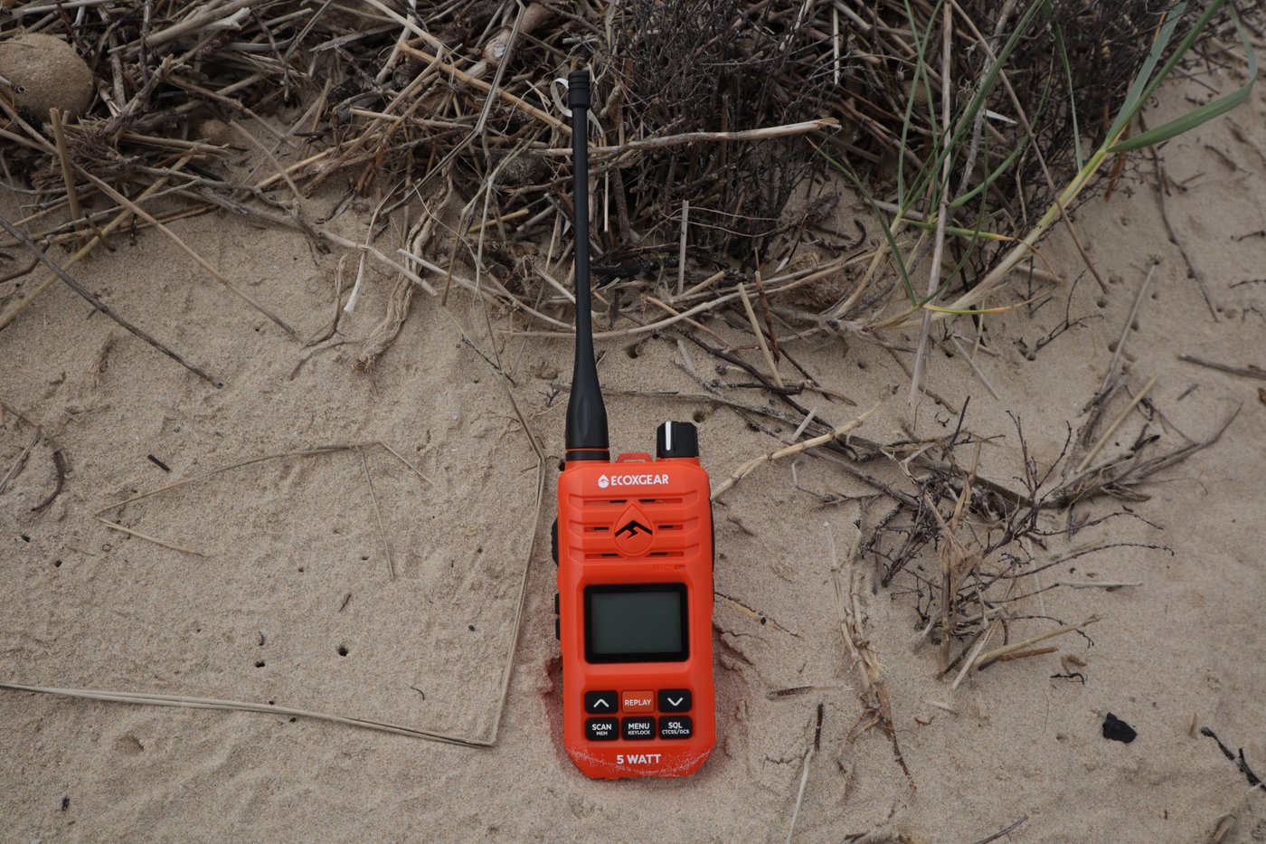 EXG510S standing upright in dune grass with antenna extended