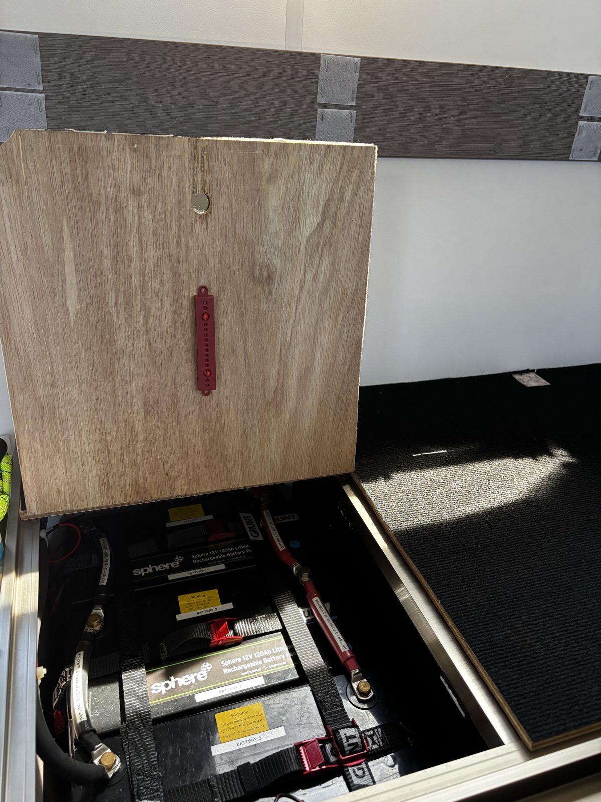 Ferosticker strip device stuck to the underside of a timber lid above a house battery bay