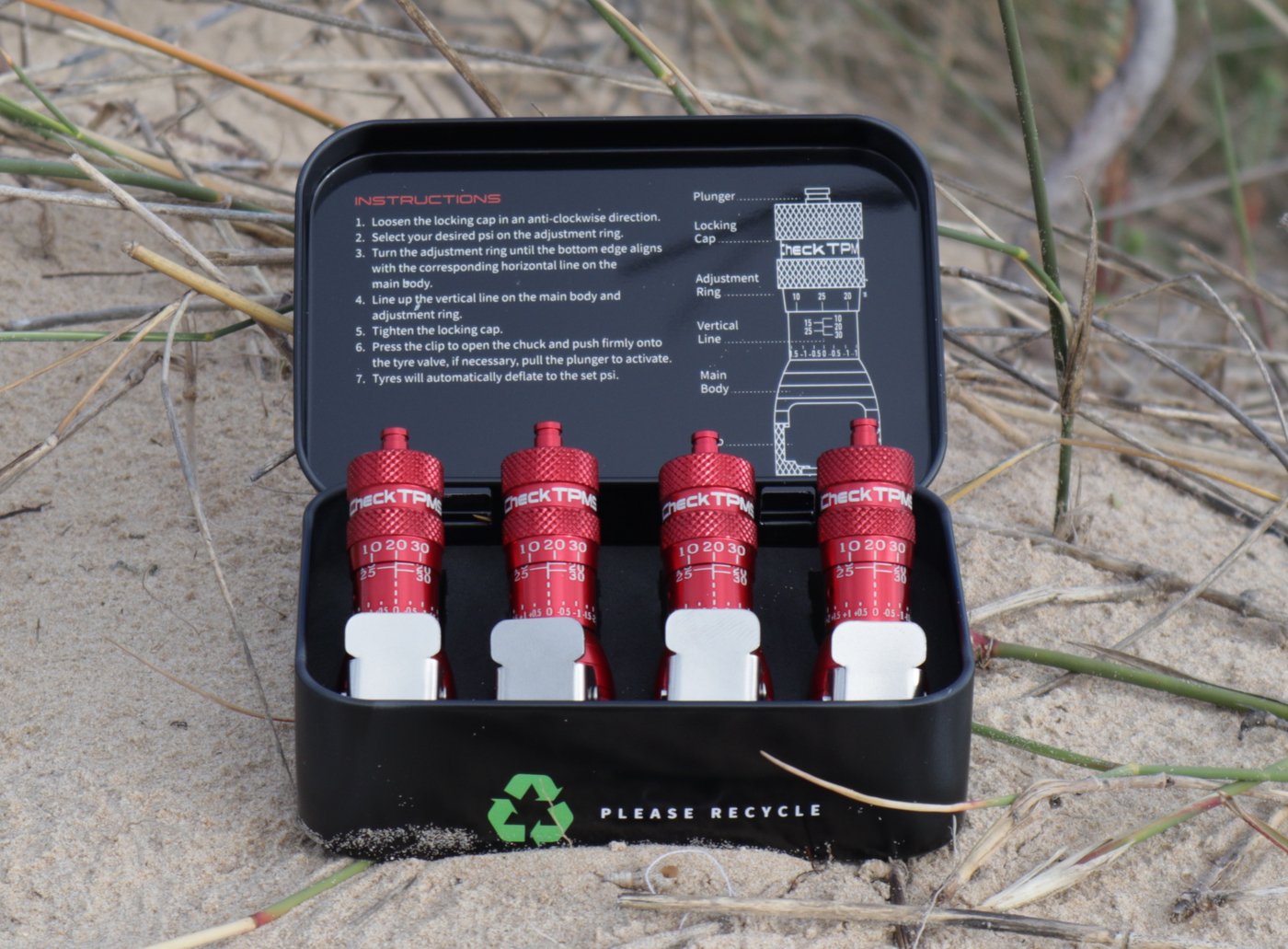 Tin case open on dune grass
