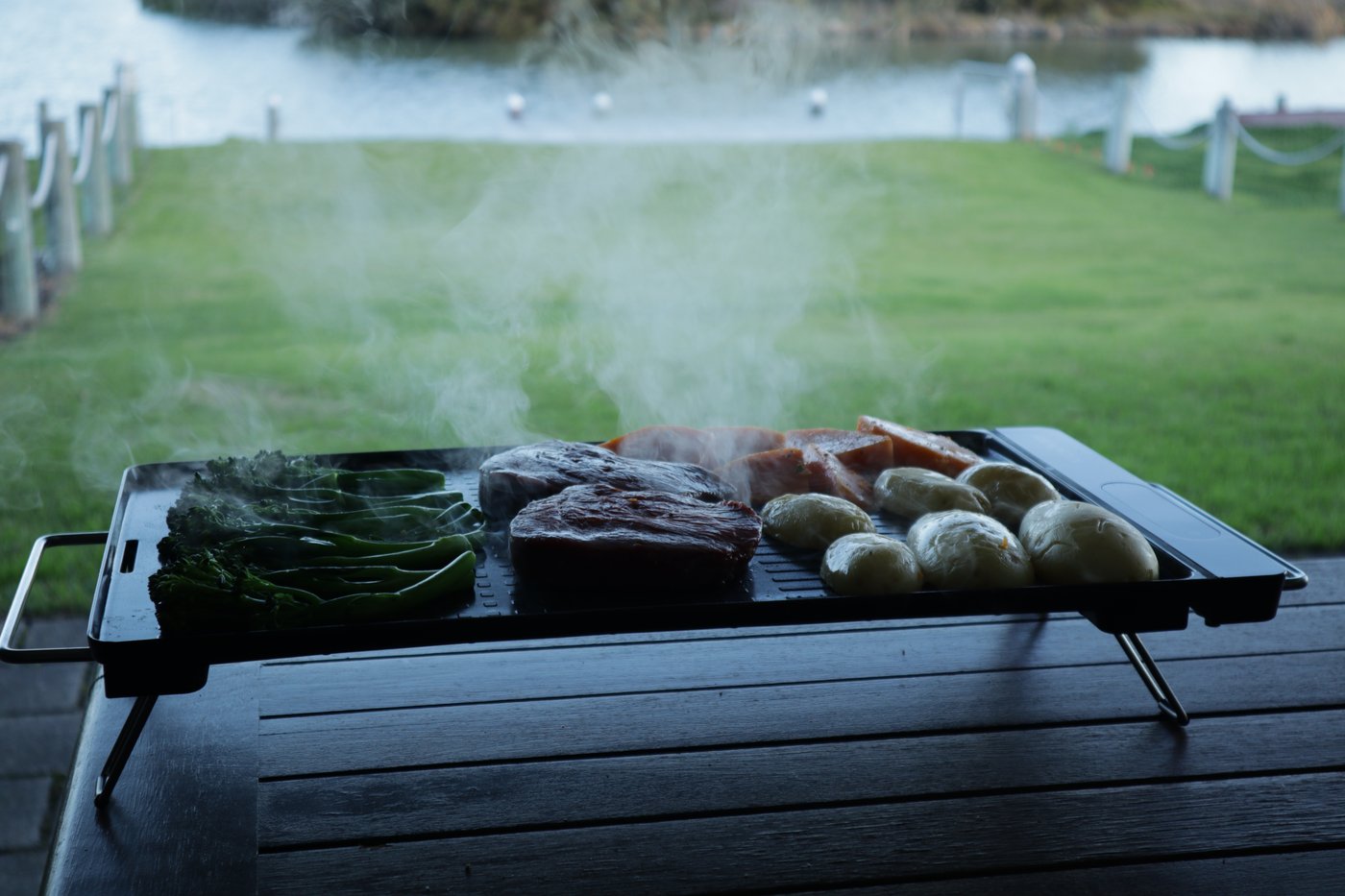 Steak, pumpkin and potatoes cooking on the plate, steam rising