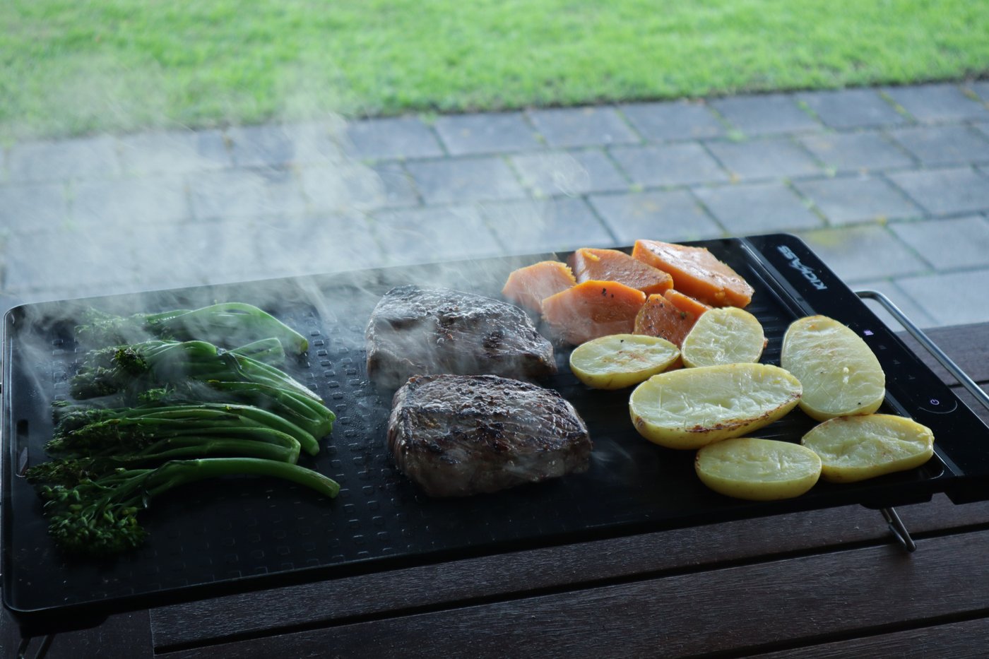 Broccolini, steak, sweet potato and potatoes cooking side by side