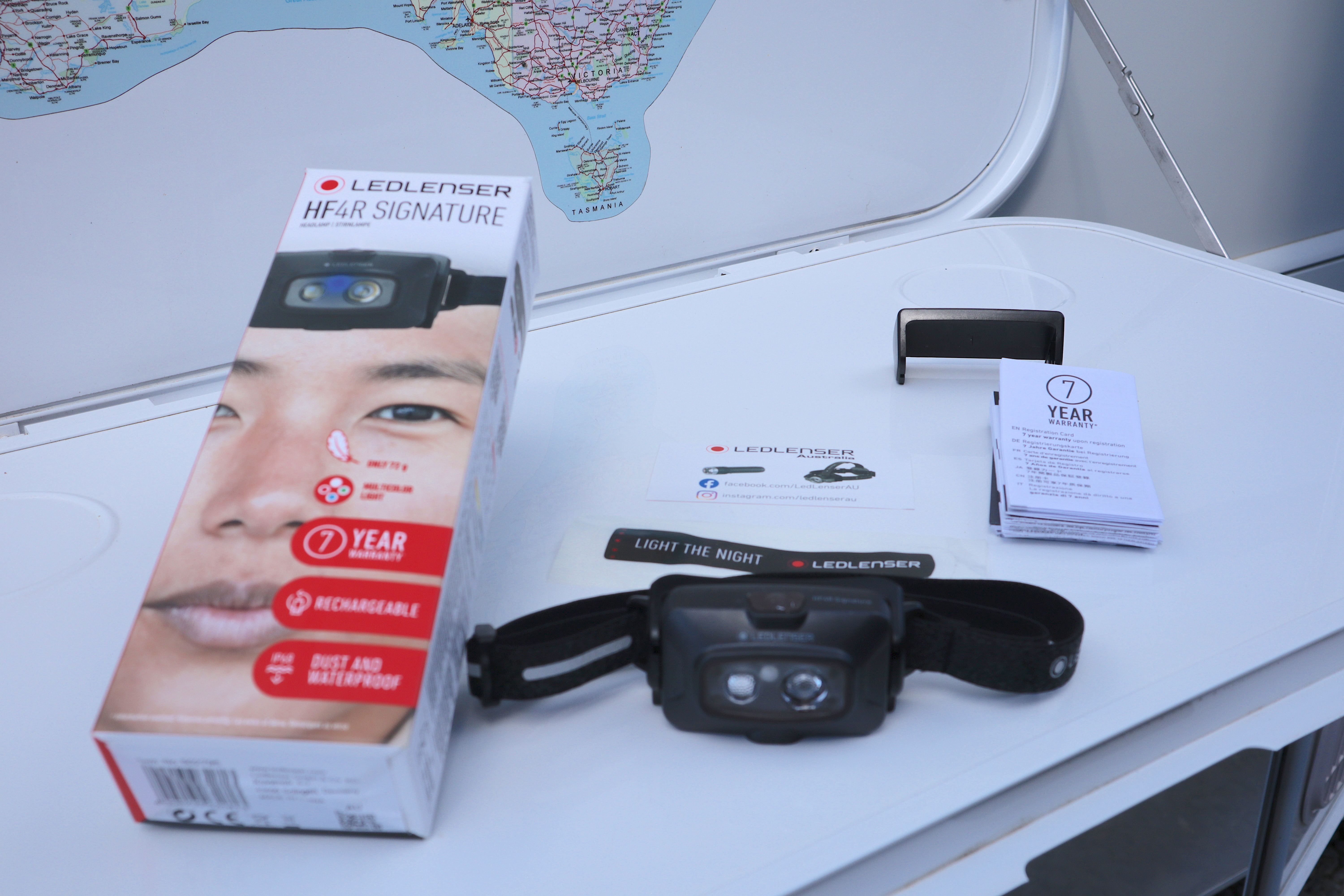 Unboxed contents laid out - headlamp, headband, magnetic charger dock and warranty registration cards