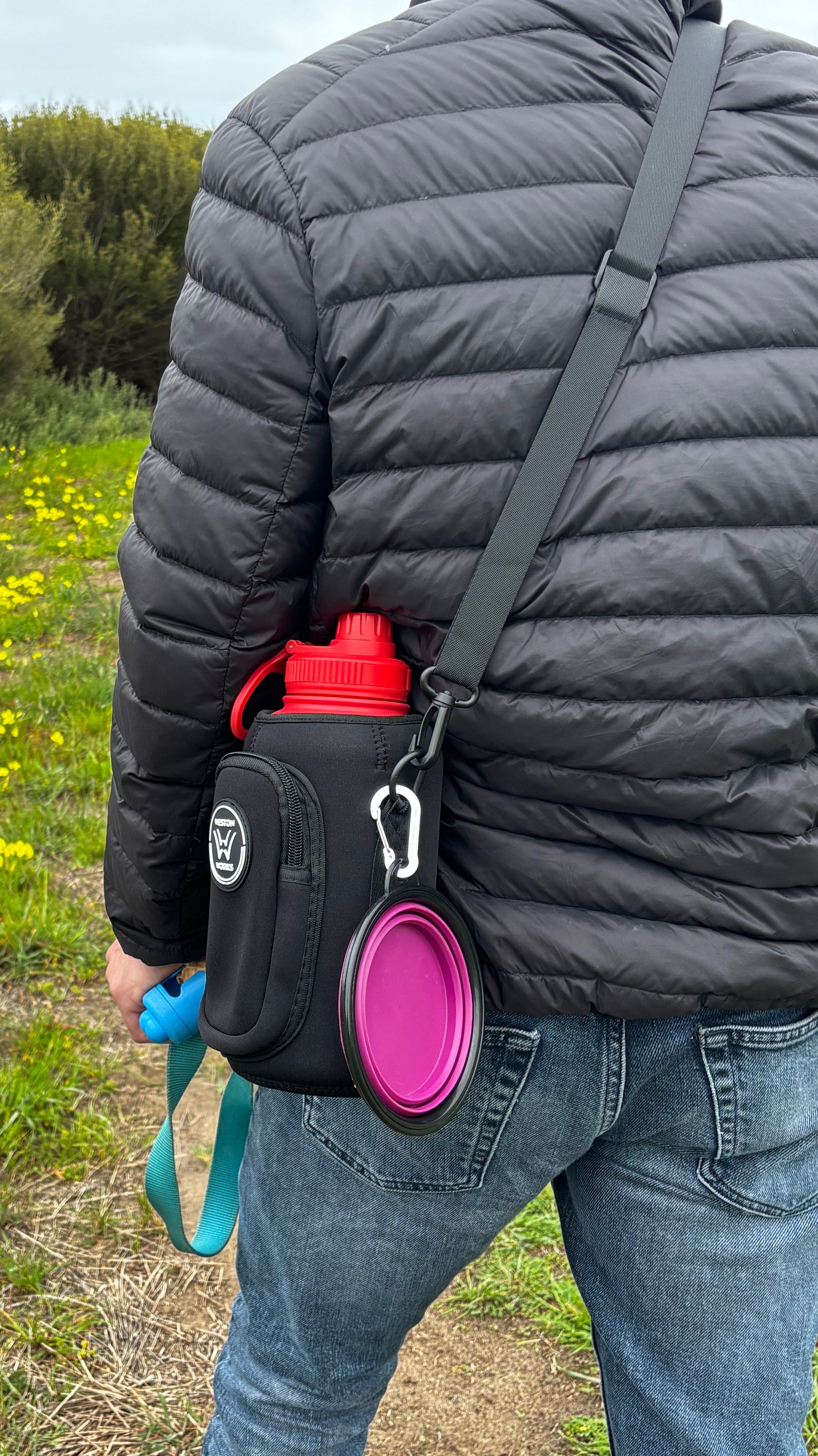 Rear view of a person wearing the WestonWorks bottle pouch while walking a dog