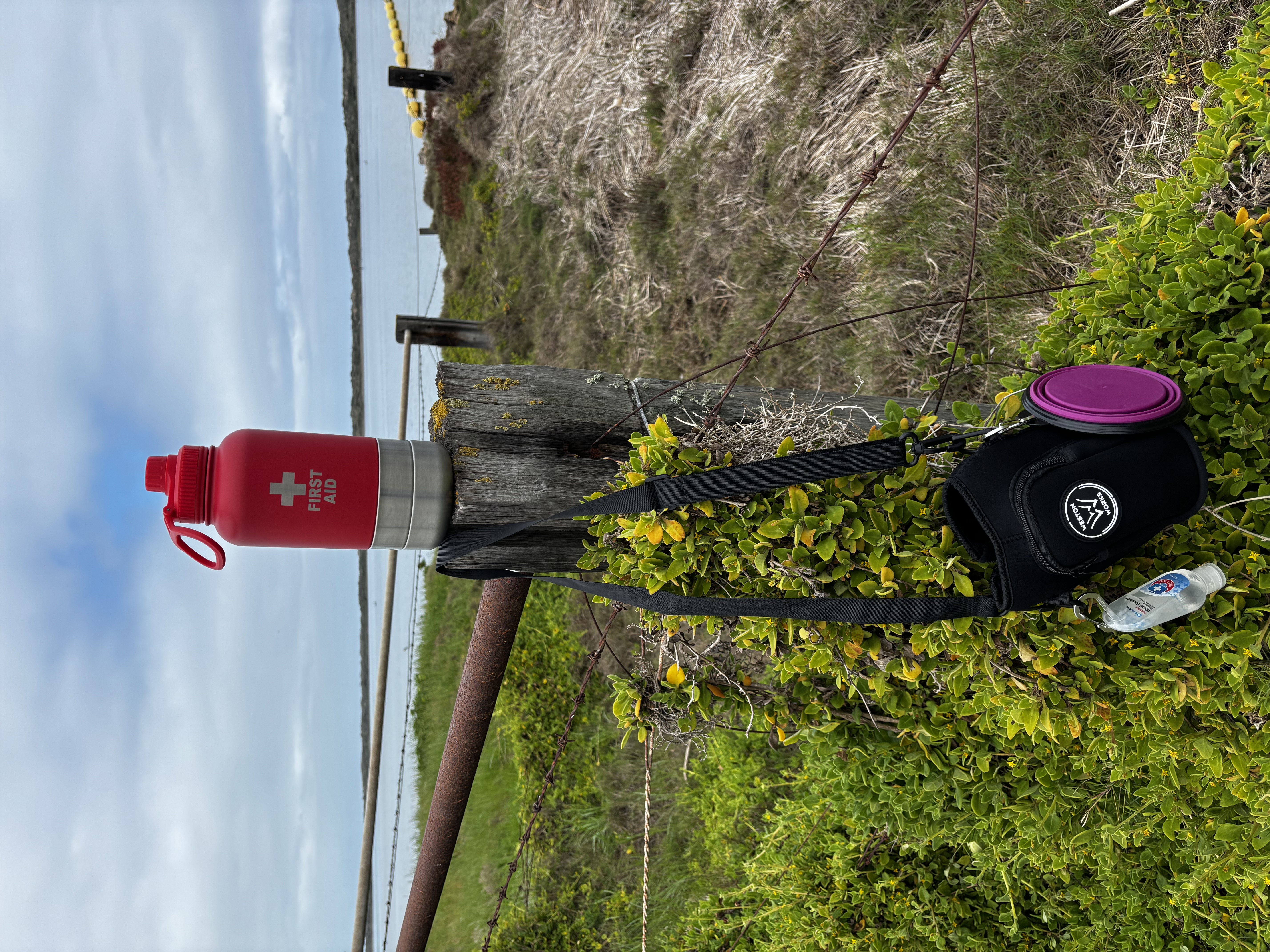 WestonWorks First Aid Bottle balanced on a fence post overlooking a lake