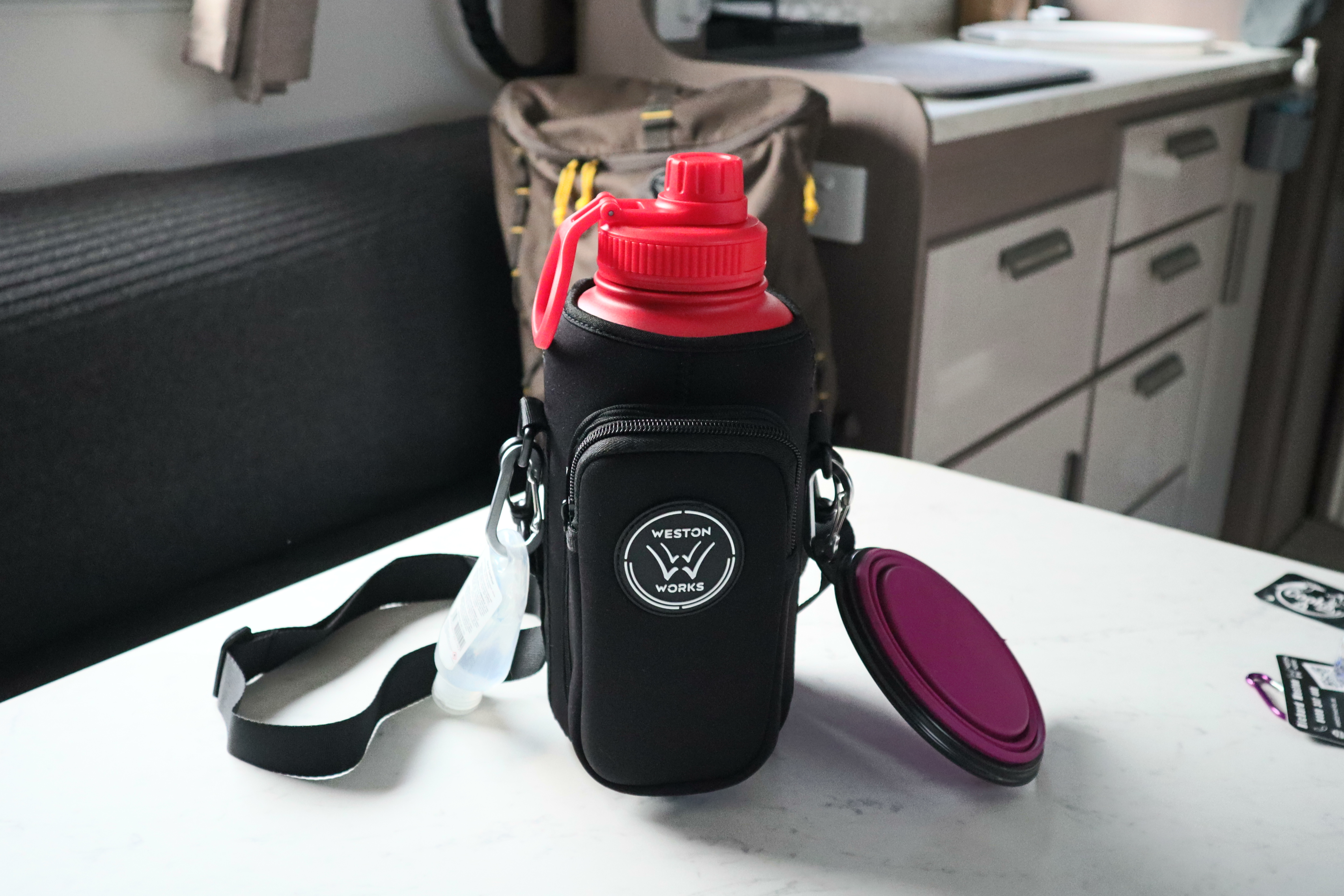 Close-up of the carry pouch with a collapsible silicone bowl clipped to the side