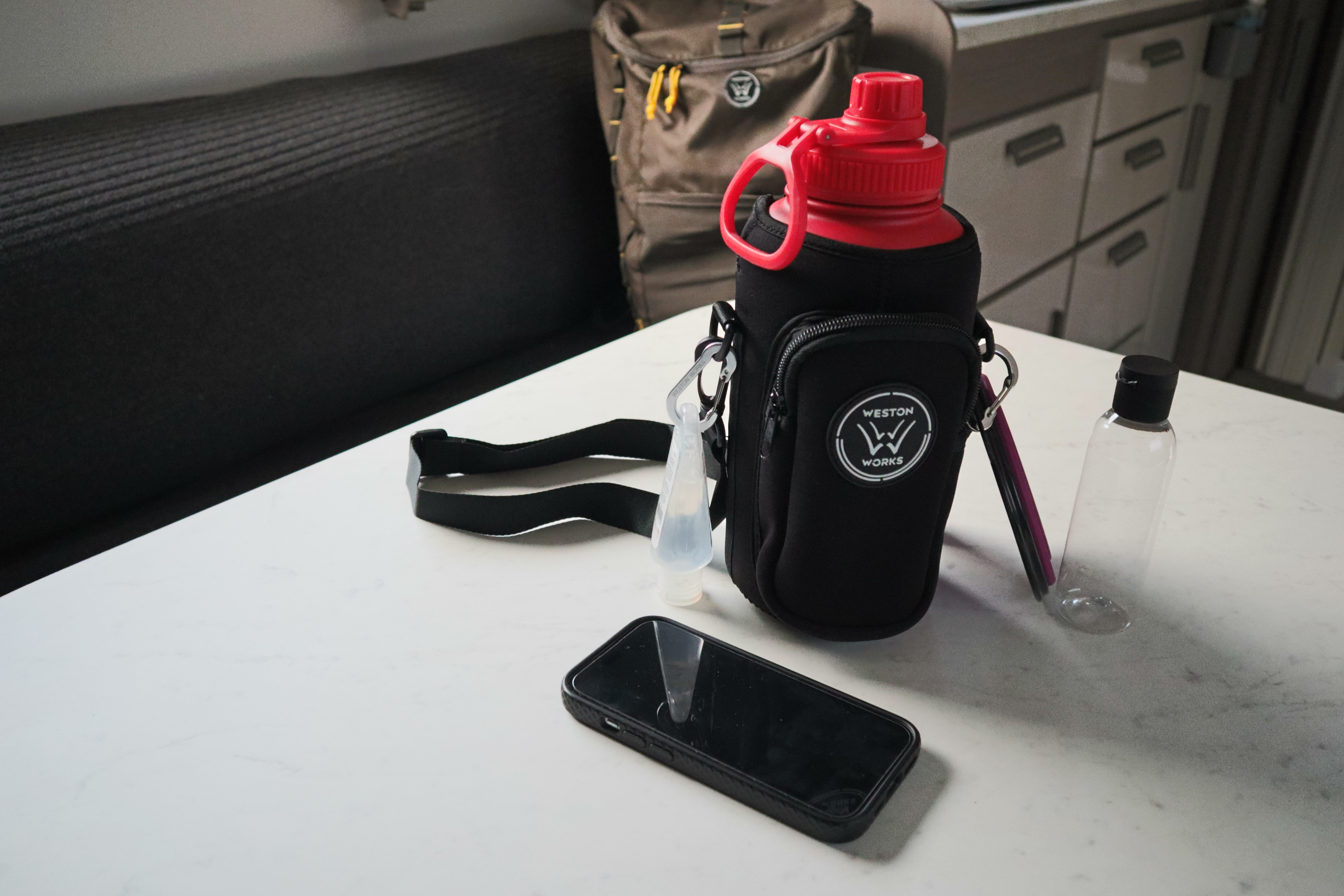 Full WestonWorks First Aid Bottle kit laid out on a table with a phone alongside