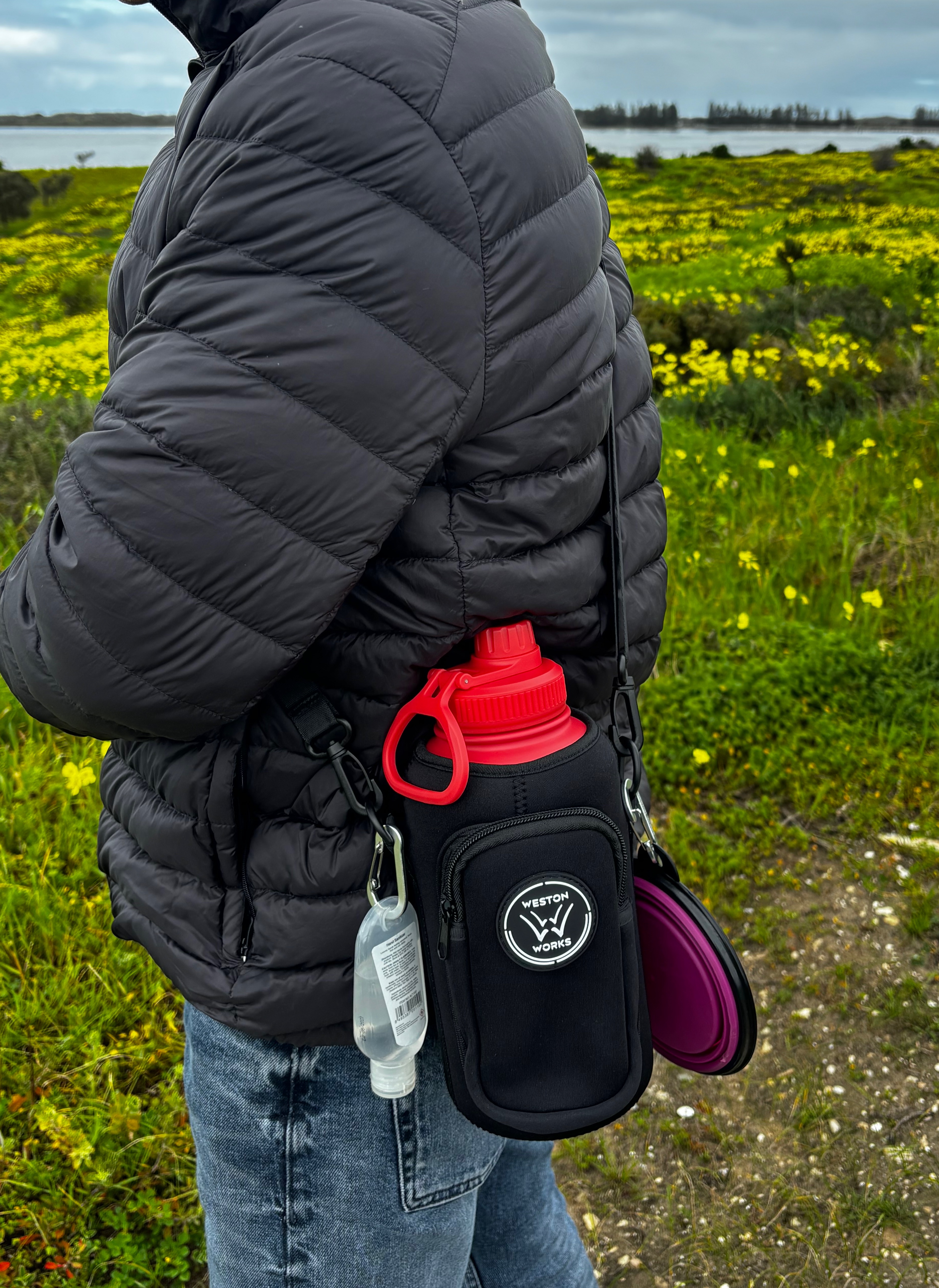 Person wearing the WestonWorks First Aid Bottle pouch crossbody while walking outdoors